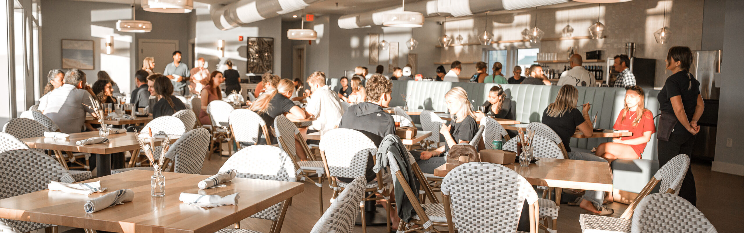 Bustling coastal restaurant dining room packed with guests — best Father's Day waterfront dining at NC coast