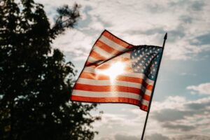 American flag waving in the breeze with sunlight and cloudy sky — 4th of July in Surf City NC