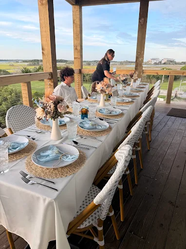 A private event table with flowers and place settings on Marina Joe’s waterfront deck